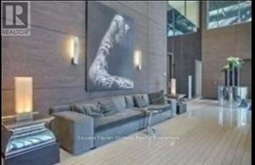 Toronto (Mimico) condo for rent - A living room with a couch and a large painting on the wall.
