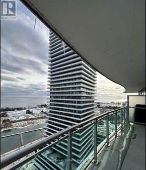 Toronto (Mimico) condo for rent - A tall building with a glass facade is seen from a balcony.