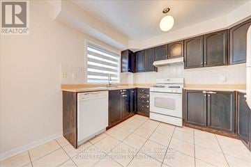 Mississauga (Hurontario) townhouse for rent - A kitchen with white appliances and black cabinets.