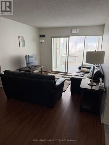 Brampton (Fletcher's Creek South) condo for rent - A living room with a black couch and a television.