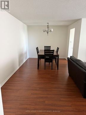 Brampton (Fletcher's Creek South) condo for rent - A dining room with a wooden floor and a chandelier.
