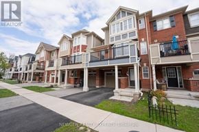 Brampton (Fletcher's West) townhouse for rent - A row of townhouses with balconies and a sign that says Newgen Realty Experts Brokerage.