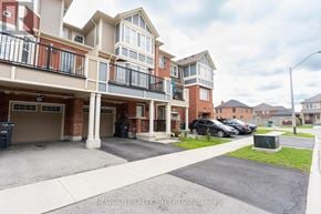 Brampton (Fletcher's West) townhouse for rent - A multi-story apartment building with a parking lot in front.