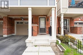 Brampton (Fletcher's West) townhouse for rent - A red brick house with a white porch and a black gate.