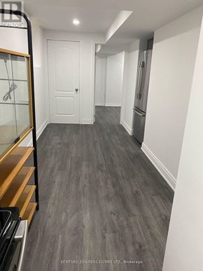 Mississauga (East Credit) apartment for rent - A hallway with a white door and a fridge on the right side.