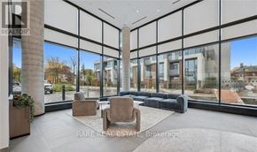 Kitchener condo for rent - A modern living room with a large window overlooking a cityscape.