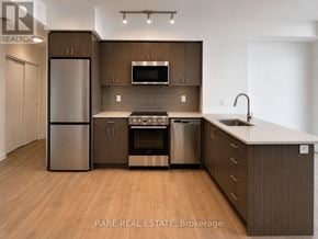 Kitchener condo for rent - A modern kitchen with wooden cabinets and stainless steel appliances.