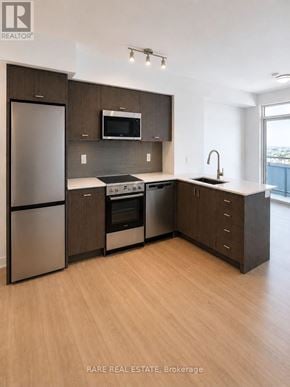 Kitchener condo for rent - A modern kitchen with wooden cabinets and stainless steel appliances.