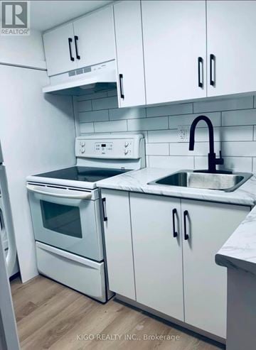 Kitchener apartment for rent - A white kitchen with a sink and a stove.