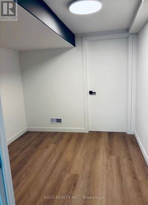 Kitchener apartment for rent - A room with a white door and a wooden floor.