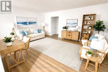 Hamilton (Durand) house for rent - A living room with a white couch, a wooden table, and a painting of a beach scene on the wall.