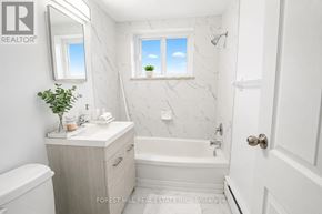 Hamilton (Durand) house for rent - A white bathroom with a marble wall and a window.