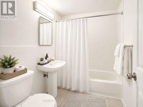 Hamilton (Durand) house for rent - A white bathroom with a toilet, sink, and bathtub.