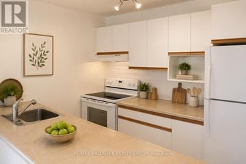 Ottawa townhouse for rent - A kitchen with white cabinets and a bowl of green apples on the counter.