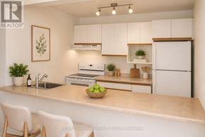 Ottawa townhouse for rent - A kitchen with white cabinets and a countertop with a bowl of green apples on it.