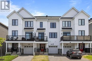 Ottawa townhouse for rent - A white two-story townhouse with a balcony and a garage.
