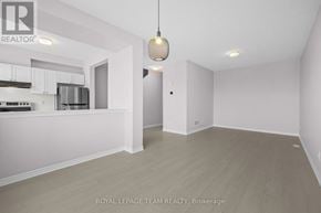 Ottawa townhouse for rent - A spacious room with a kitchen area to the left and a doorway leading to another room.