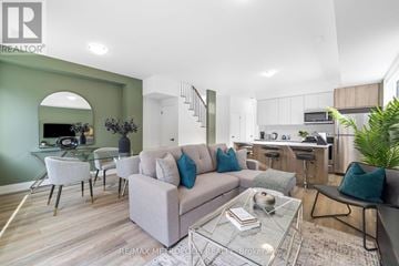Toronto (Dufferin Grove) fourplex for rent - A modern living room with a glass coffee table and a grey sofa.