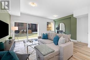 Toronto (Dufferin Grove) fourplex for rent - A living room with a couch, a chair, and a television.