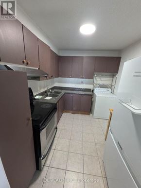 Toronto (Agincourt South-Malvern West) condo for rent - A kitchen with brown cabinets and a black stove top oven.