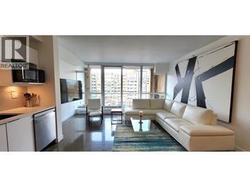 Vancouver apartment for rent - A modern living room with a large couch and a television.