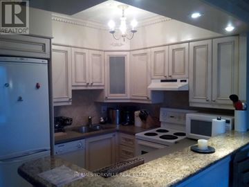 Toronto (Waterfront Communities) condo for rent - A kitchen with a refrigerator on the left and a microwave on the counter.