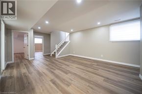 Brantford apartment for rent - A spacious room with wooden flooring and a staircase.