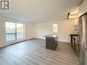 Toronto (South Riverdale) apartment for rent - A spacious room with a kitchenette and a view of the outside.