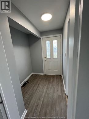 Windsor apartment for rent - A white door with a glass window is in the middle of a room with grey walls and wooden flooring.