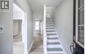 Hamilton apartment for rent - A staircase with white railings leads up to a door.