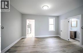 Hamilton apartment for rent - A spacious room with wooden flooring and white walls.
