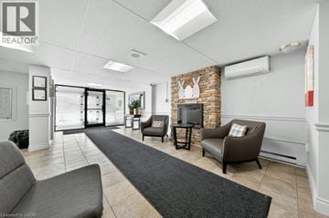 Kitchener condo for rent - A living room with a grey couch and a stone fireplace.