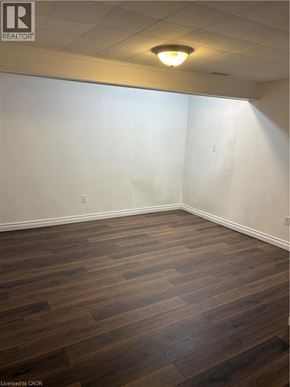 Stoney Creek apartment for rent - A room with wooden flooring and white walls.