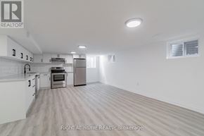 Oshawa (Donevan) apartment for rent - A spacious kitchen with white cabinets and a stainless steel refrigerator.
