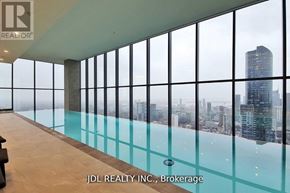 Toronto (Bay Street Corridor) condo for rent - A glass-walled room with a pool and a view of the city.