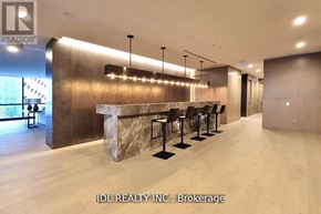 Toronto (Bay Street Corridor) condo for rent - A modern bar area with a row of black stools and a marble counter.