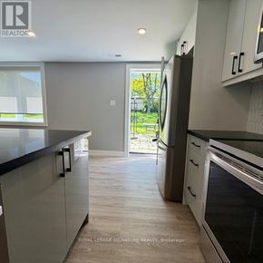 Toronto (Victoria Village) apartment for rent - A modern kitchen with a refrigerator, oven, and cabinets.