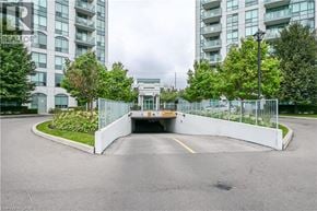Mississauga condo for rent - A parking lot with a white fence and a building in the background.