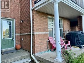 Toronto (Centennial Scarborough) townhouse for rent - A red brick house with a green door and a sign that says REALTOR.