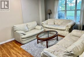 Toronto (Centennial Scarborough) townhouse for rent - A living room with a beige couch, a glass coffee table, and a rug.