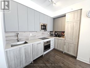 Vaughan (Concord) condo for rent - A kitchen with wooden cabinets and a clock on the wall.
