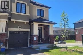 Brantford townhouse for rent - A house with a realtor sign in front of it.