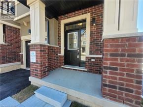 Brantford townhouse for rent - A brick house with a black door and a sign that says "REALTOR".