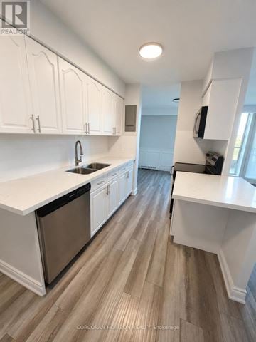 Hamilton (Ainslie Wood) condo for rent - A kitchen with white cabinets and a wooden floor.