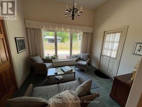 Rideau Lakes apartment for rent - A living room with a couch, chairs, and a window with a view of a yard.