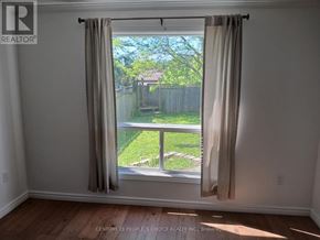 Guelph (Kortright West) apartment for rent - A room with a window showing a backyard.