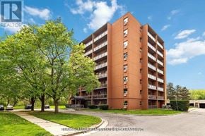 London North (North C) condo for rent - A tall apartment building with a green lawn in front.