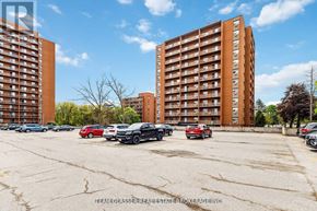 London North (North C) condo for rent - A parking lot with cars and two apartment buildings in the background.