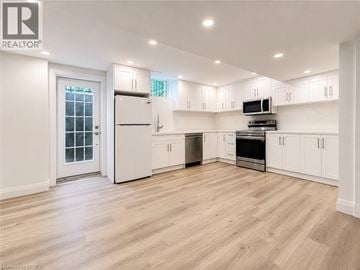 Binbrook apartment for rent - A spacious kitchen with white cabinets and a wooden floor.