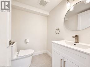 Binbrook apartment for rent - A white bathroom with a toilet, sink, and mirror.